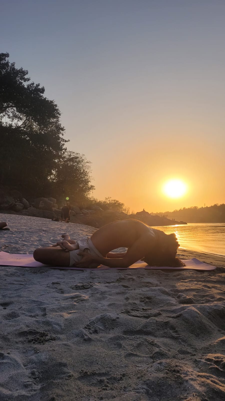 Yoga practice by the river at sunset