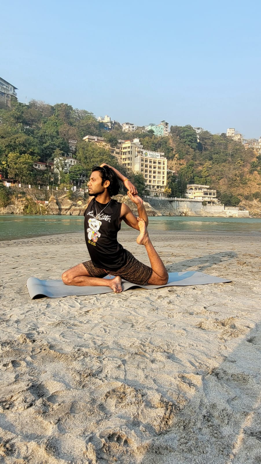 Seated spinal twist yoga pose by the Ganges river